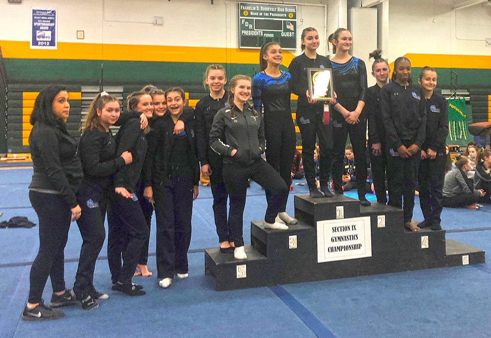 The Wallkill gymnastics team poses with the championship plaque after winning the Section 9 championship meet at Roosevelt High School in Hyde Park on Feb. 19, 2020.